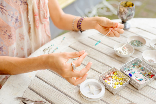 the girl is engaged in needlework from natural stones and beads