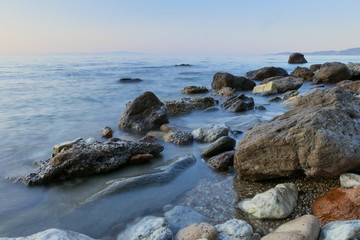Fototapeta na wymiar rocks in sea by sunset. long shutter