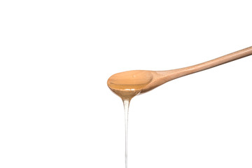 isolated wooden spoon with honey on a white background