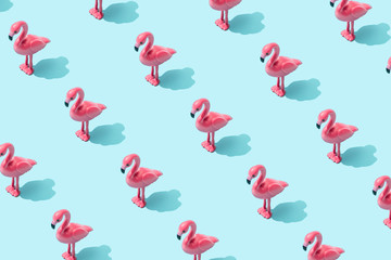 Trendy sunlight Summer pattern made with pink flamingo toy on bright light blue background. Minimal...