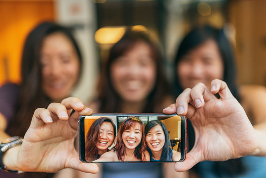 Asian friends women taking a selfie in the coffee shop.