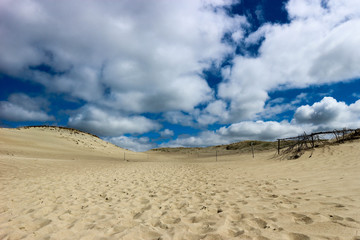 Fantastic beautiful view of sand dunes on Curonian Spit, Lithuania under the endless bright blue sky with clouds