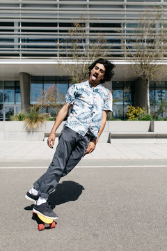 Confident hipster skating on street