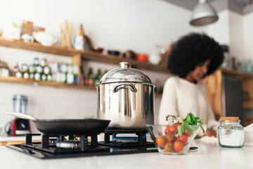 Unrecognizable black woman cooking in the kitchen at home.