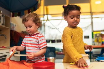 Adorable babies playing together in the kindergarten.