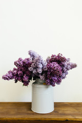 Awesome purple bouquet of lilac flowers in a stylish vase on a white background