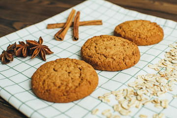 Oatmeal cookies, flakes, cinnamon and badyan at kitchen textile during breakfest