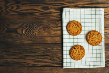 Fototapeta na wymiar Round oatmeal cookies, at kitchen textile during breakfest