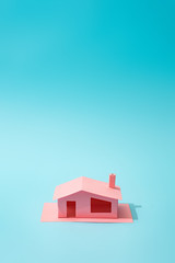 Trendy sunlight Summer composition made with pink paper house on bright light blue background. Minimal summer concept.