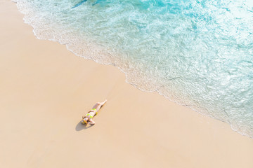 Fototapeta na wymiar Young woman laying on sand beach