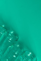4 green glass jars on a green background with room for text