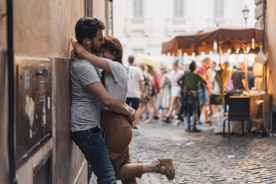 Young Couple Listening Music on the Headphones and kissing in th