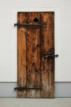 Old rustic wooden door with iron hinges