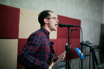 Singer playing bass guitar.