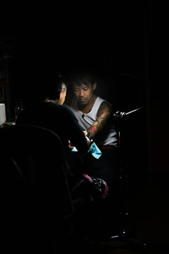 Professional asian tattooer makes a tattoo