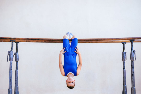 Gymnastics, young boy practicing on parallel bars
