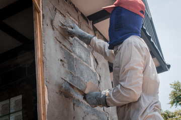 Construction workers plastering building wall using cement plaster