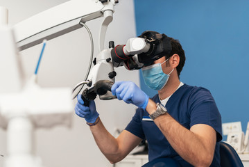 Dentists during a dental intervention using microscope