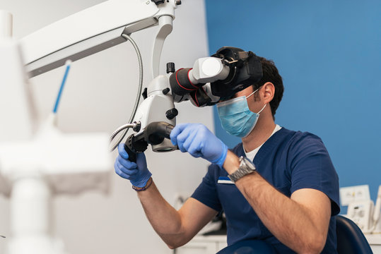Dentists during a dental intervention using microscope