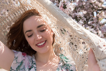 Woman shielding herself from sun with crocheted cardigan