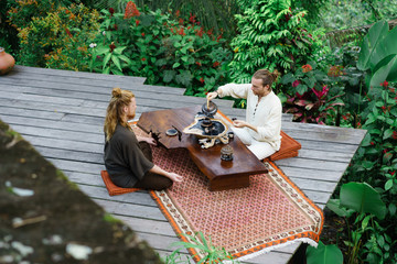 Men having traditional tea ceremony on terrace
