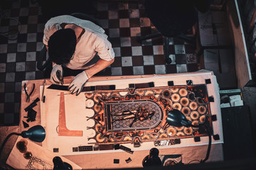 Process of restouration antoque stained glass by expirienced restorer at his workshop. Top view,...
