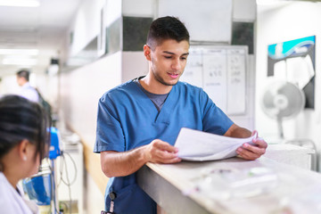 Young male hospital worker with a patient journal