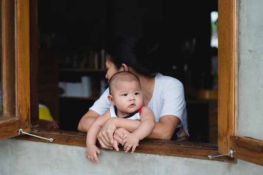 Asian mom and her son sitting by the window