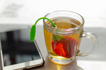 Cup of morning tea and a smartphone on the table