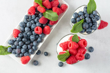 Cottage cheese with cream, raspberry and blueberry garnished with fresh mint.