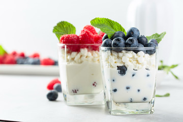 Cottage cheese with cream, raspberry and blueberry garnished with fresh mint.