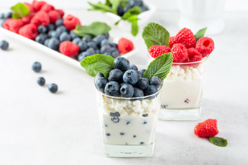 Cottage cheese with cream, raspberry and blueberry garnished with fresh mint.