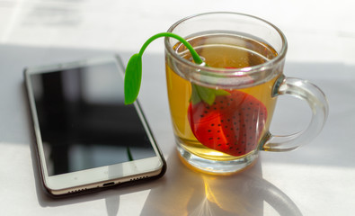 Cup of morning tea and a smartphone on the table