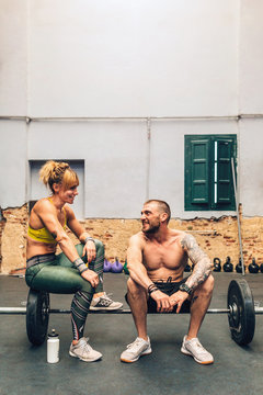 Athletes talking on barbell