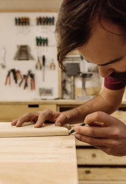 Craftsman marking wood with pencil