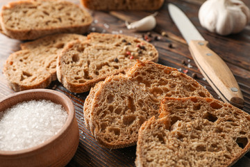 Flat lay composition with freshly baked bread on wooden background, closeup and space for text