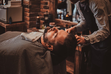 Attractive brutal man just got good beardcare from talanted trendy barber.