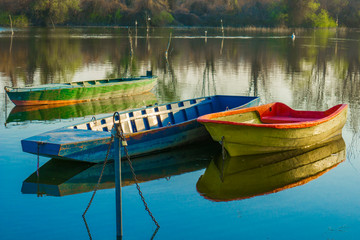Wooden boats in the calm lake water on a spring day