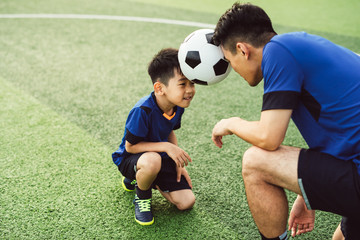father and son playing soccer