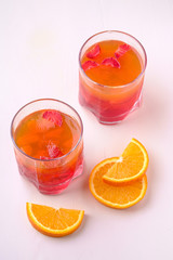 Jelly dessert with strawberries in drink glass with orange slices nearby