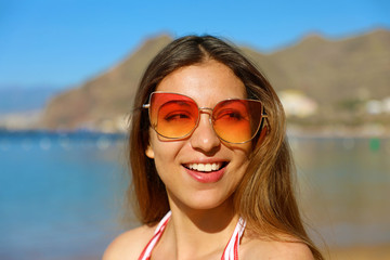 Portrait of young pretty woman with sunglasses on the beach