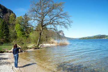 Fototapeta na wymiar Junge Frau steht an einem See im Salzburger Land