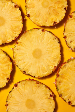 Flat lay background of round slices of juicy ripe pineapple on a