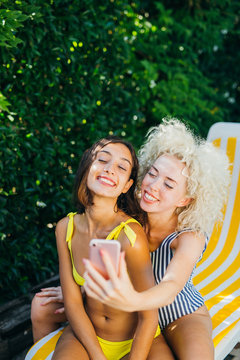 two firends taking a selfie near the pool