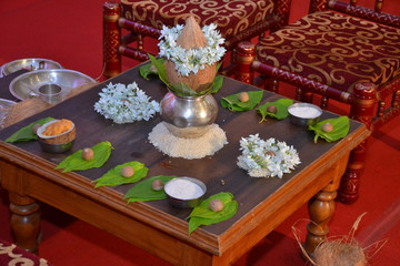 Copper Kalash with coconut decorated using flowers on it, betel leaf and betel nuts decorated on a table (chowrang) for marathi wedding