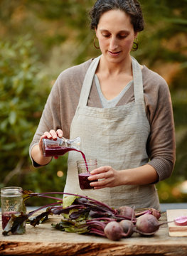 Woman making homemade fermented probiotic beet kvass drink