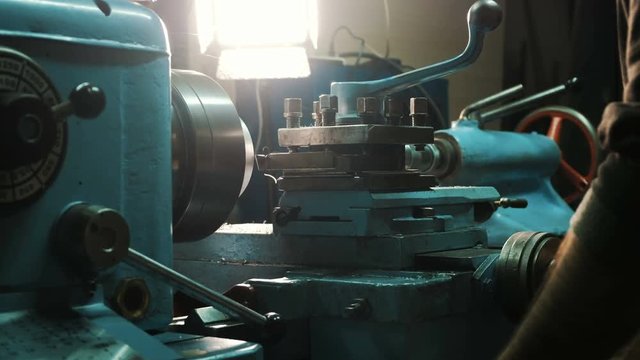 man hands work with metal lathe spinning and grinding detail