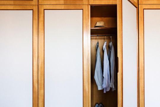 Retro wardrobe with open door revealing shirts on hangers