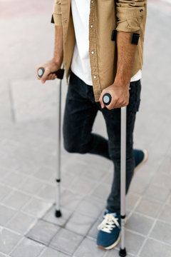 Close up of young man using crutches