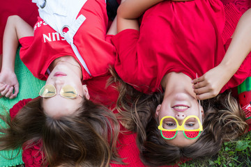 Two nice teen girls having fun eating watermelon In the park. Excellent sunny weather. Summer concept. Watermelon party, picnic, day